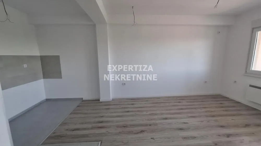 Empty room with laminate flooring and white walls.
