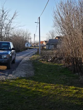 Seoski put sa kućama u pozadini i parkiranim vozilom u prvom planu. - image 10