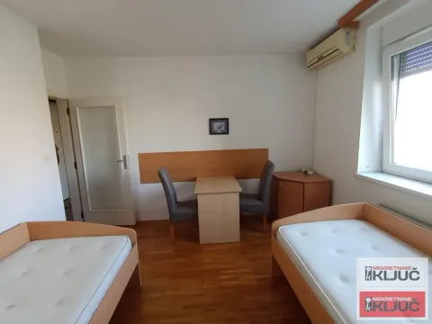 Spavaća soba sa dva kreveta i trpezarijskim stolom sa stolicama. - image 10