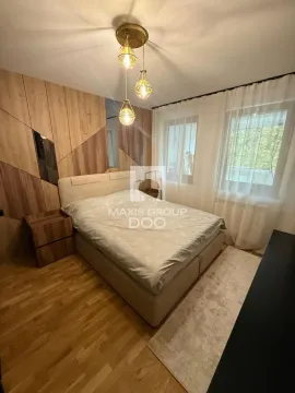 Furnished bedroom with a double bed, wooden wall panels and a chandelier. - image 10