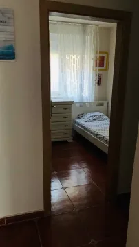 Pogled kroz vrata na urednu spavaću sobu sa krevetom i komodom. - image 5