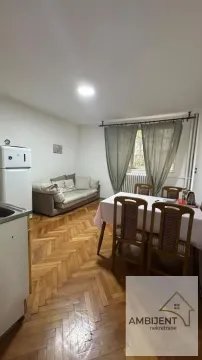 Living room with sofa, dining table, and kitchen area. - image 9