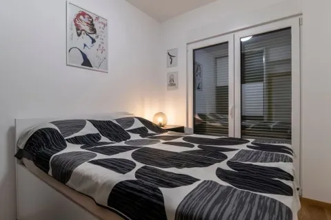 Bright bedroom featuring a double bed and decorative wall art. - image 7