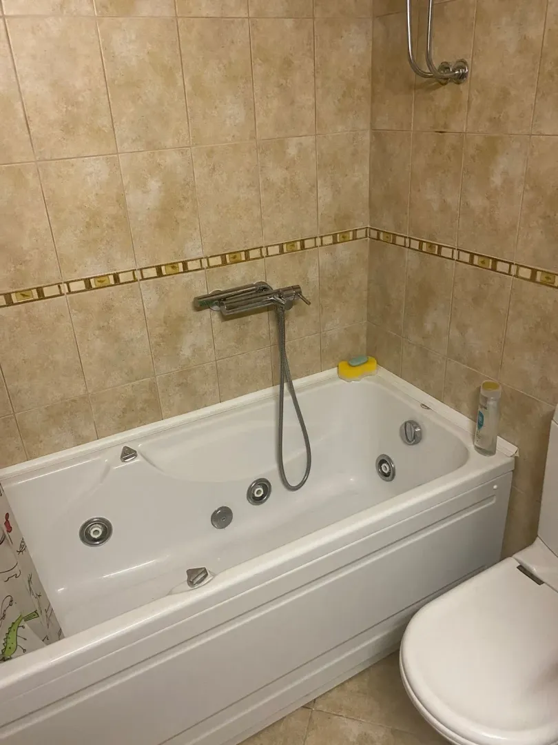 Kupatilo sa đakuzi kadom i bež keramičkim pločicama.