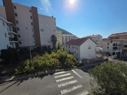 View from the window showing the street, neighboring buildings, and surrounding greenery. - image 15