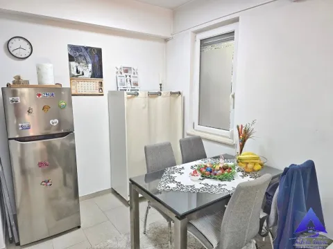 Dining area with a table, chairs, and a refrigerator within the apartment. - image 7