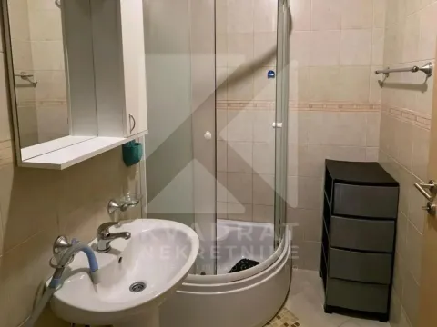 Manje kupatilo opremljeno tuš kabinom, umivaonikom i elementima za odlaganje. - image 5
