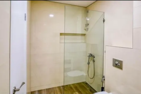 Bathroom with a walk-in shower and glass partition. - image 7