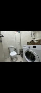 Smaller bathroom with toilet and washing machine. - image 12