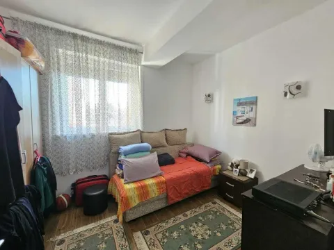 Manja spavaća soba sa ležajem, ormarom i tepisima sa šarama. - image 7