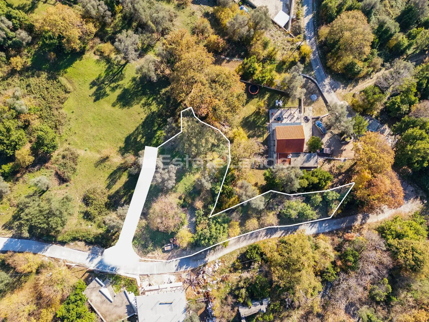 Iz vazduha snimljen plac sa ucrtanim granicama i kućom u zelenilu.