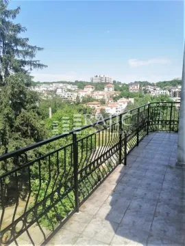 Spacious balcony with wrought iron railing and city view. - image 11