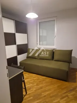 Manja spavaća soba sa zelenim kaučem, ormarom i prozorom. - image 7