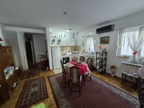 Manja kuhinja sa trpezarijskim stolom i tepisima na drvenom podu. - image 2