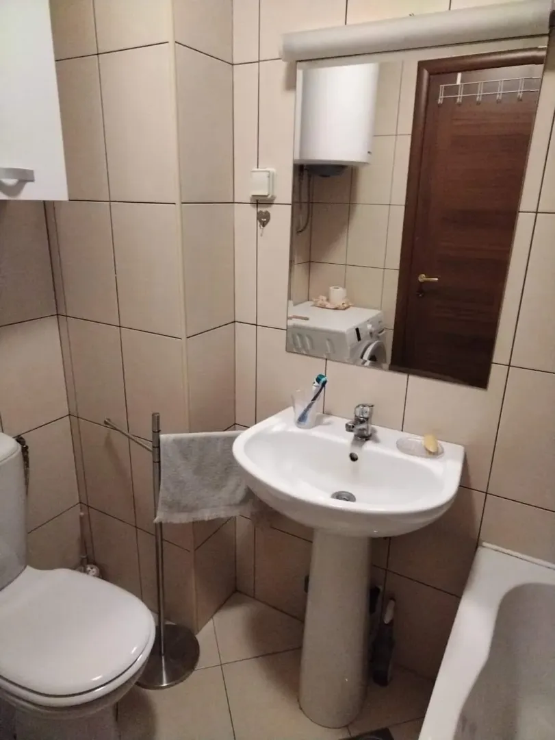 Small bathroom with a sink, toilet, and mirror.