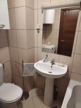 Small bathroom with a sink, toilet, and mirror. - image 13