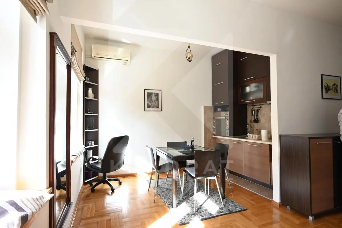 Open plan space featuring a kitchen, dining area, and a work corner.