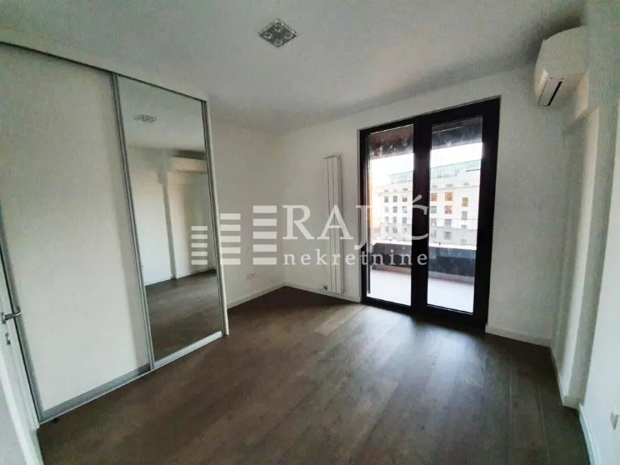 Empty bedroom with a built-in wardrobe and access to the terrace.