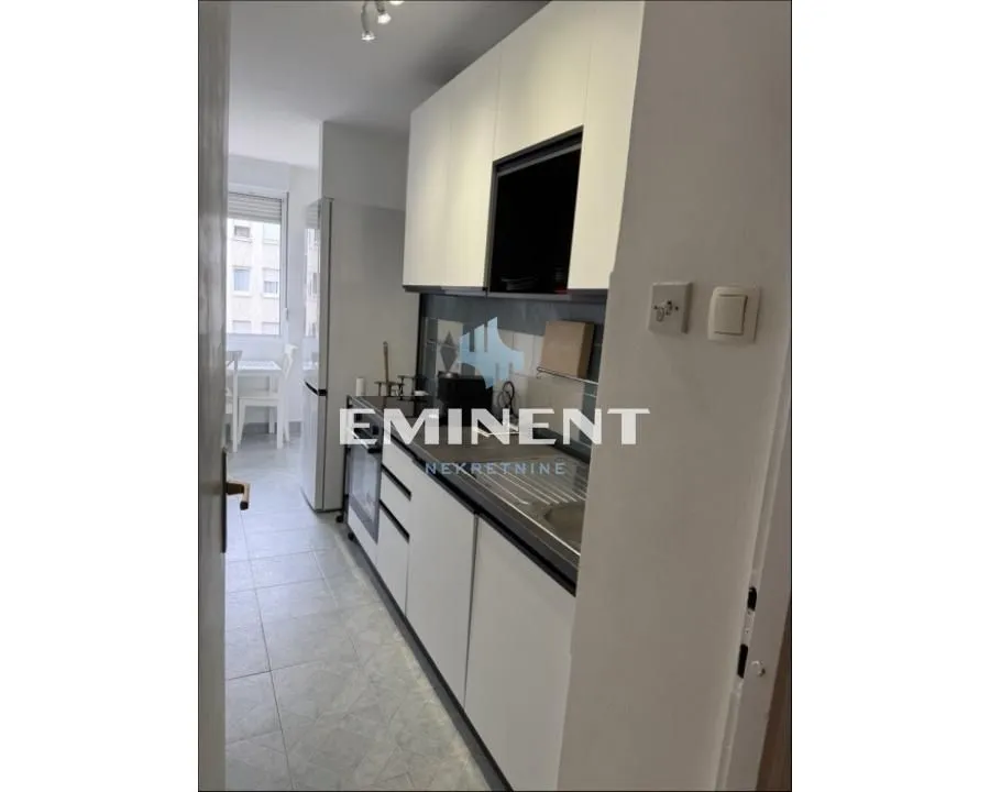 Small white kitchen with a sink and built-in units.