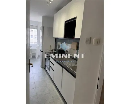 Small white kitchen with a sink and built-in units. - image 3