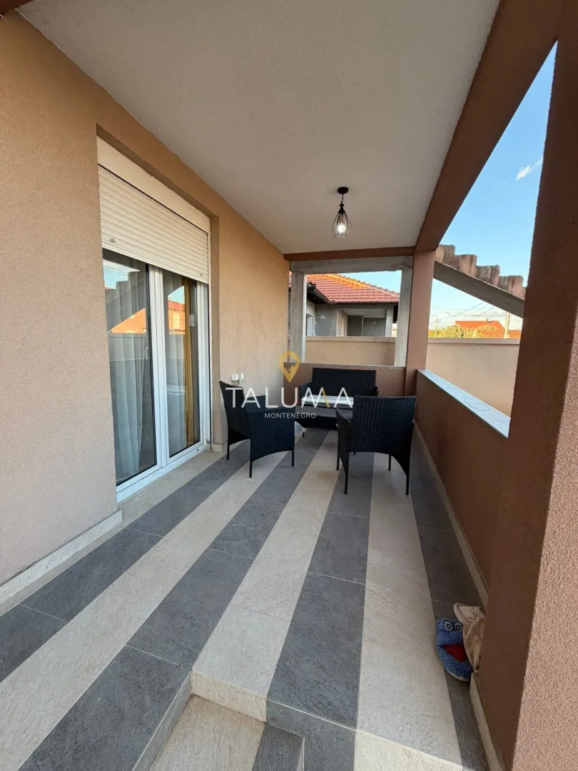 Covered terrace with outdoor seating furniture.