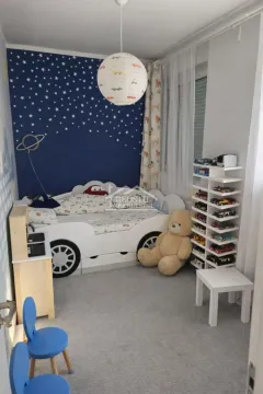 Children's bedroom with a car-shaped bed, toys, and a blue star-patterned wall. - image 6