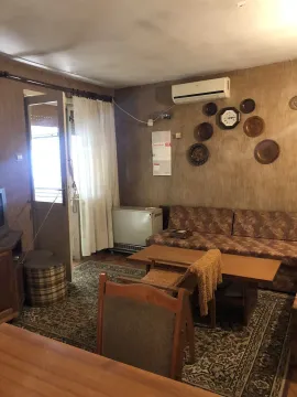 Jednostavna dnevna soba sa garniturom za sjedenje i drvenim stolom. - image 12