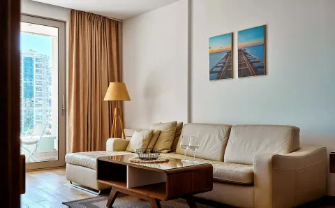 Living room with a sectional sofa, coffee table, and access to the terrace. - image 7