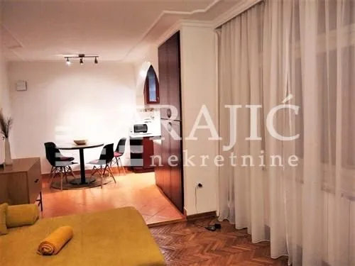 Living room with dining area and view of the kitchen.