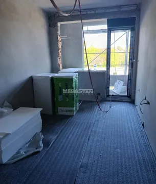 Prazna prostorija u toku renoviranja sa građevinskim materijalom i izlazom na terasu. - image 3
