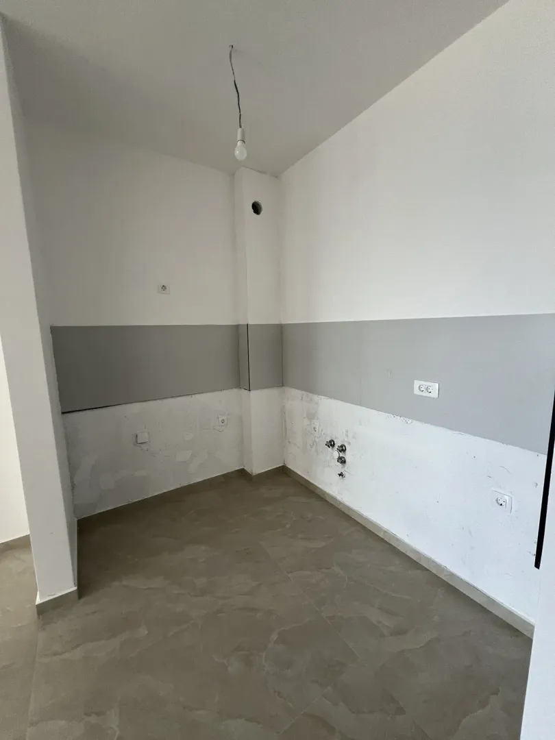Unfinished corner of a room with utility connections in a new building.