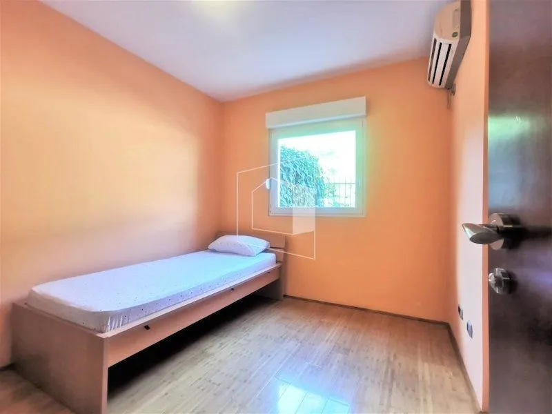Small bedroom with a bed and orange walls.