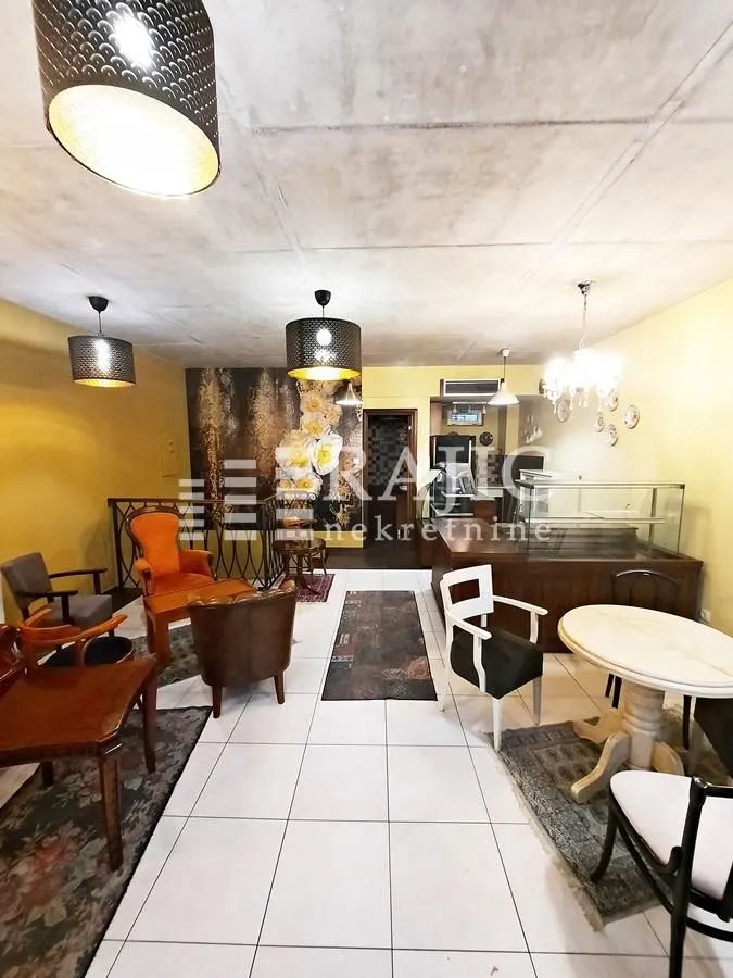 Spacious living room with seating furniture and a dining table.