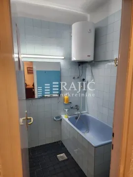 Smaller tiled bathroom with a bathtub and water heater. - image 9
