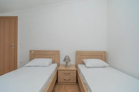 Spavaća soba sa dva odvojena kreveta i noćnim stočićem. - image 4