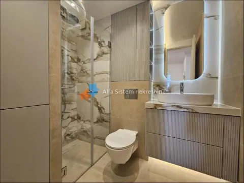 Moderno opremljeno kupatilo sa tuš kabinom, umivaonikom i ugradnom wc šoljom. - image 3