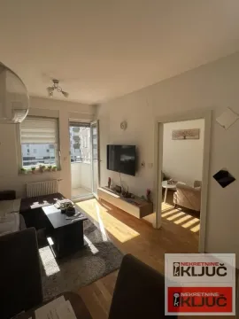 Dnevna soba sa garniturom, TV-om i izlazom na terasu. - image 3