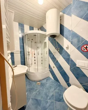 Bathroom with a shower cabin, washbasin, and toilet. - image 10