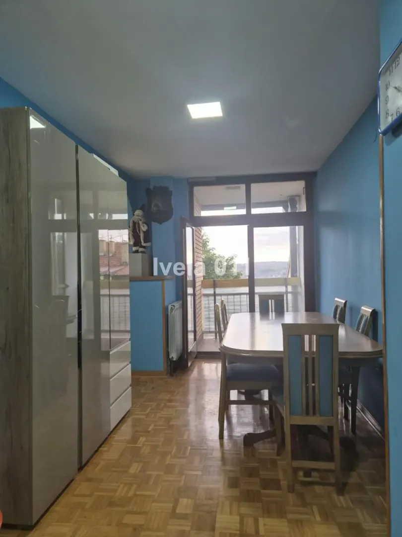 Dining area with a wooden table and chairs and access to the terrace.