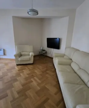 Living room with white sofa set and parquet flooring. - image 2