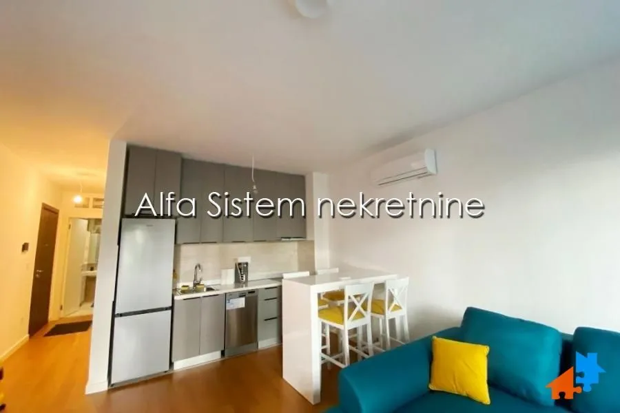 Small kitchen with grey cabinets and a breakfast bar connected to the living room.