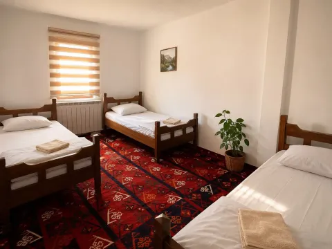 Bedroom with three wooden beds, a red rug, and a window. - image 5