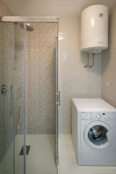 Moderno opremljeno kupatilo sa tuš kabinom i veš mašinom. - image 7