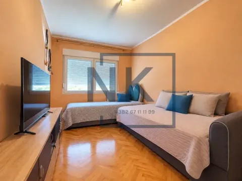 Namještena spavaća soba sa dva kreveta i televizorom. - image 7