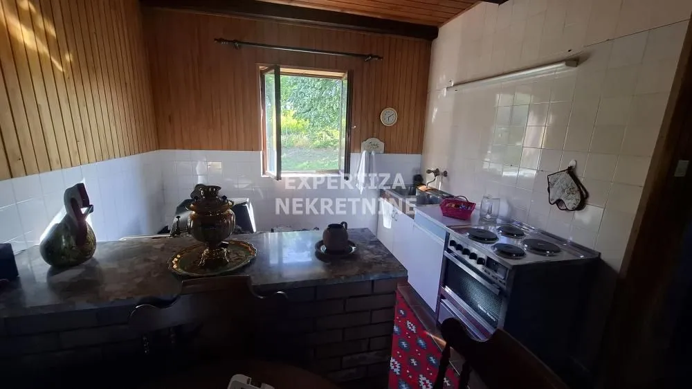 Older kitchen with a dining area and a window overlooking nature.