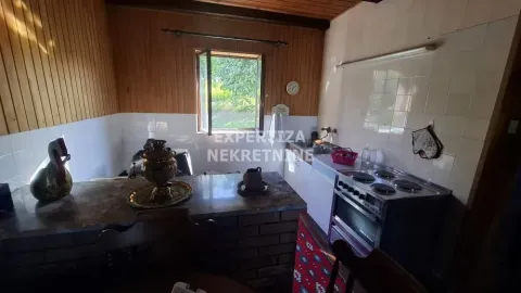 Older kitchen with a dining area and a window overlooking nature. - image 9