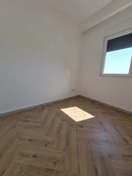 Prazna soba sa belim zidovima i drvenim podom. - image 6