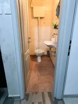 Pogled iz hodnika na manje kupatilo sa WC šoljom i umivaonikom. - image 17