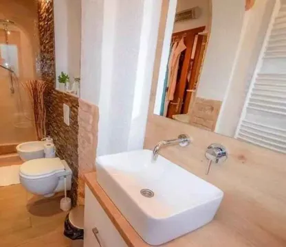 Kupatilo opremljeno umivaonikom, WC šoljom i tuš kabinom. - image 6