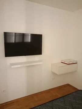 Zid sa televizorom i visećom komodom u dnevnoj sobi. - image 6